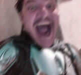 blurry pedro in his mando costume without his helmet, smiling with grogu in his arm almost maniacally